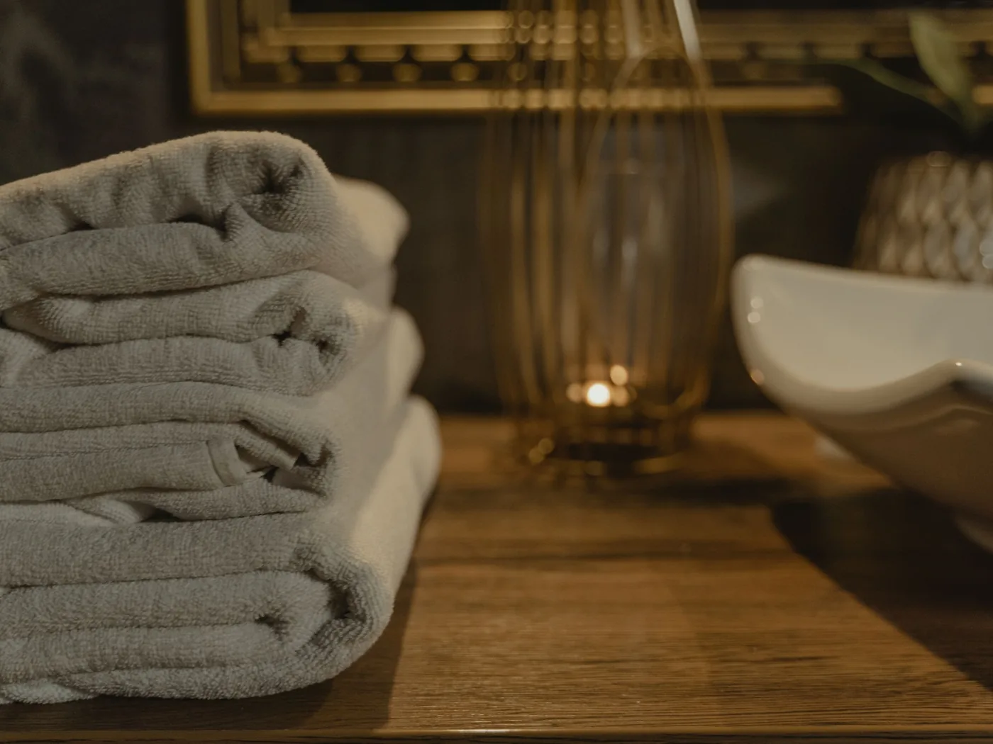 Neatly folded towels beside a candle representing careful home care